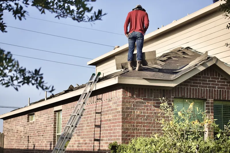 Professional roofer working on a residential roof in Milford Center